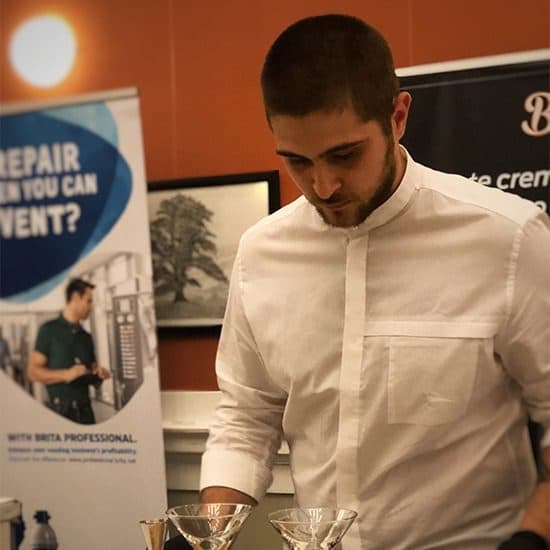 István Pongrácz, campion național Coffee in Good Spirits 2018, la stația de concurs, cu pahare de cocktail în față