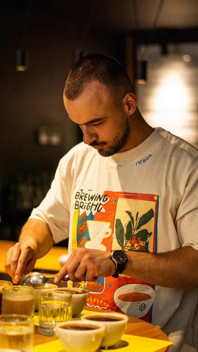 David Pahomi, campion național la Cup Tasters, aplecat peste cești la o sesiune de degustare