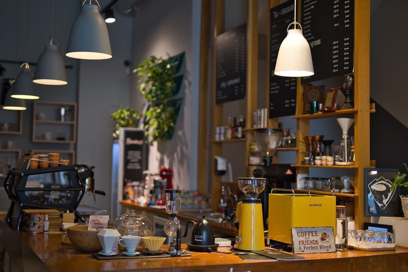 Barul First Coffee din București, cu metodele de filtru înșirate pe blat și meniul pe perete